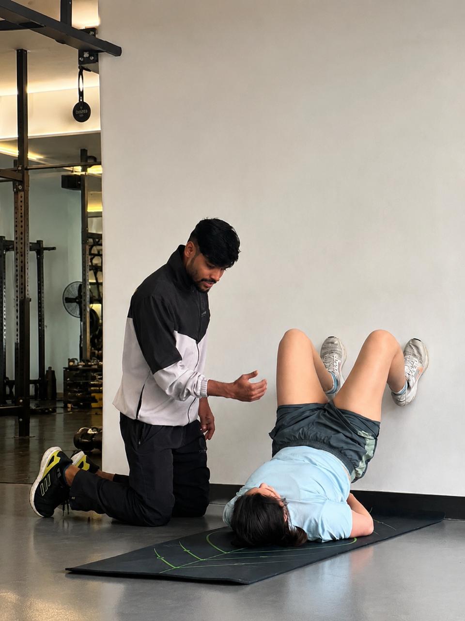 Farhan coaching a client through a mobility drill